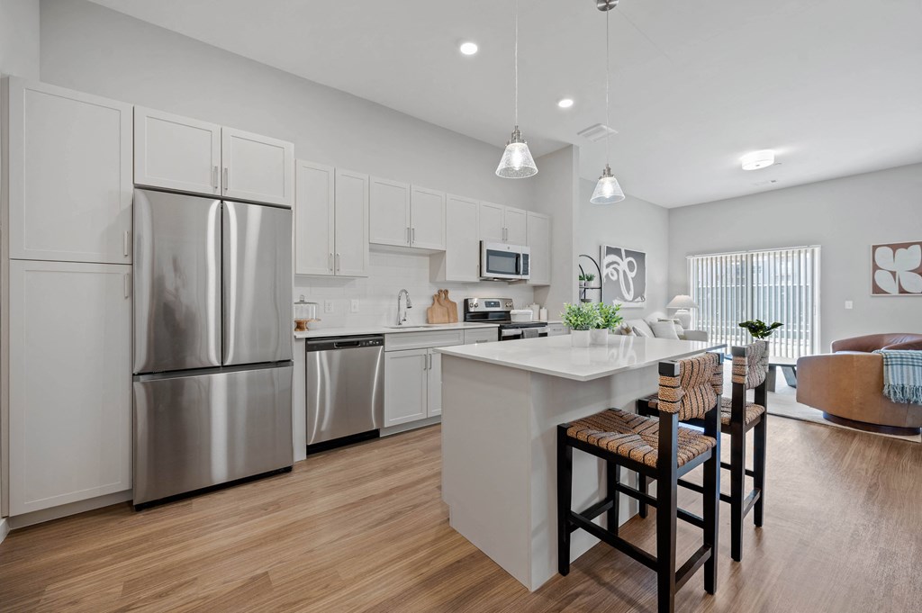 an open kitchen and dining area with a stainless steel refrigerator