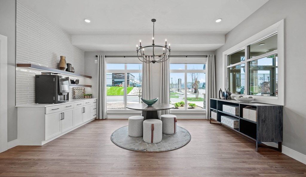 an open kitchen and living room with a round table and a chandelier