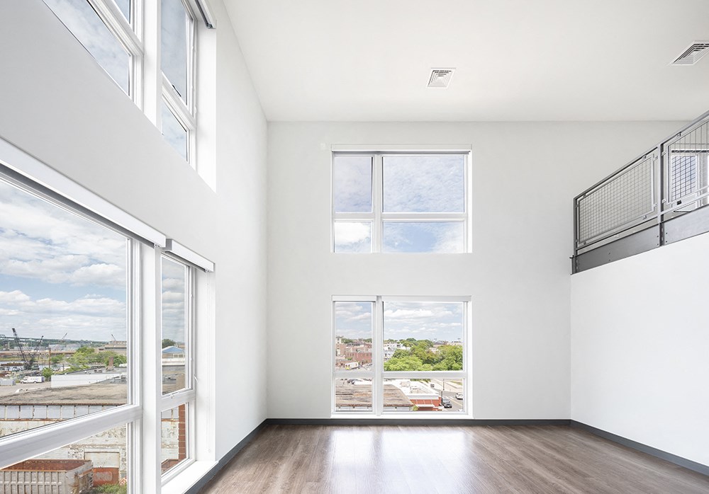 a living room with a large window and hardwood floors