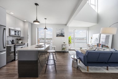a kitchen and living room with a large window and a view of Boston Harbor