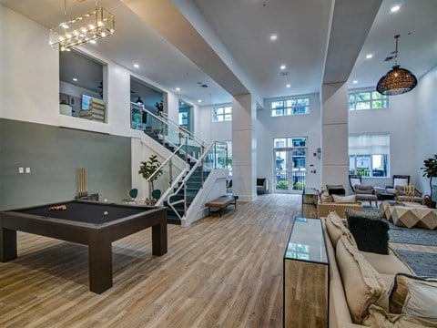 a large living room with a pool table and a staircase