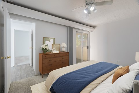 A bedroom with a bed, dresser, and sliding glass doors.