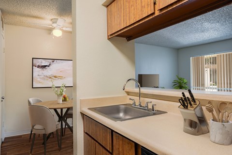 A kitchen with a table and chairs and a sink.