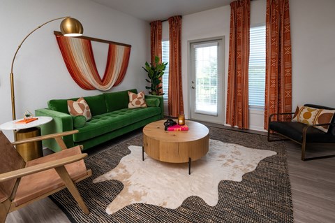 A living room with a green couch and a wooden coffee table.
