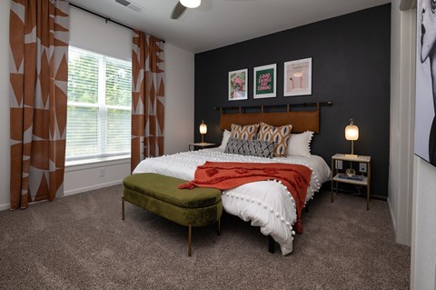 a bedroom with a bed and a chair in front of a window