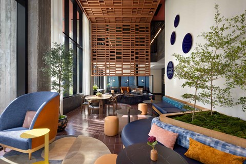 A modern living room with a blue chair and a wooden ceiling.