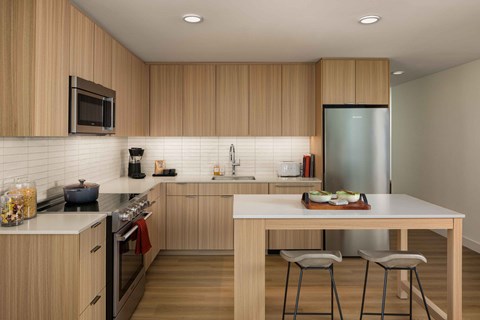A modern kitchen with wooden cabinets and a white countertop.