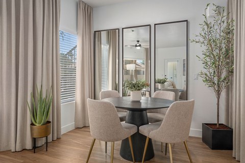 A dining room with a round table and chairs.