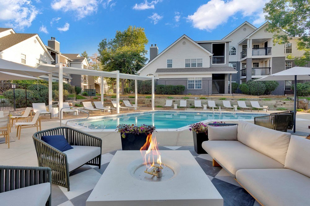 A poolside area with a lit candle on a table.