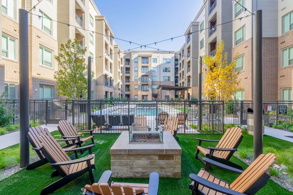 firepit with lounge chairs and pool area