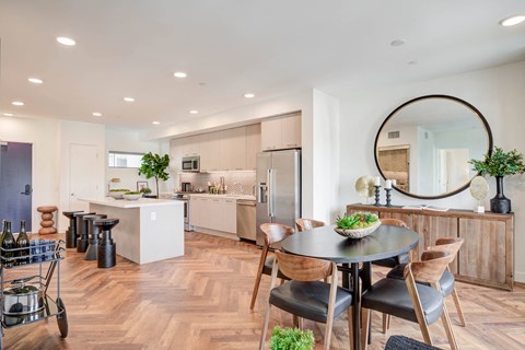 A modern kitchen with a dining table and chairs.
