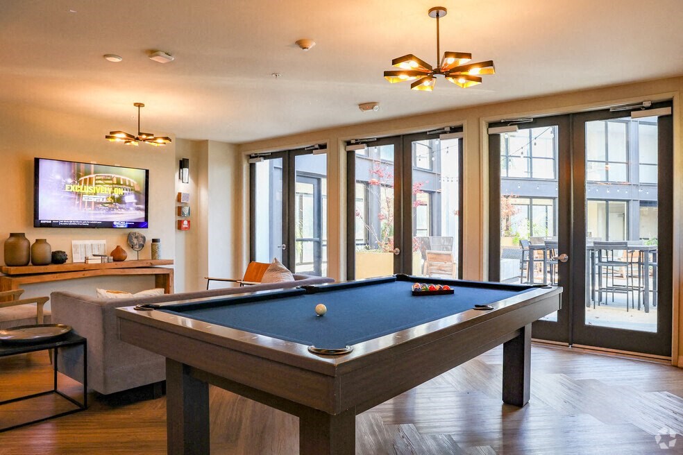 a pool table in a living room with a tv