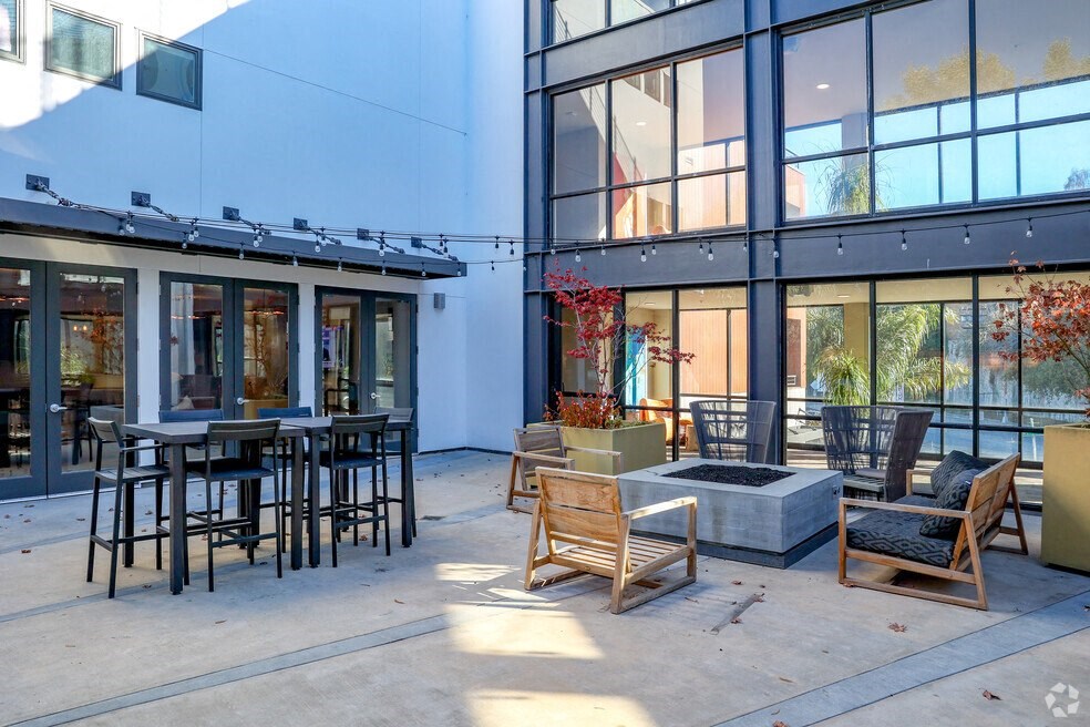 a courtyard with tables and chairs outside of a building