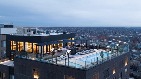 a large building with a pool on top of it overlooking a city