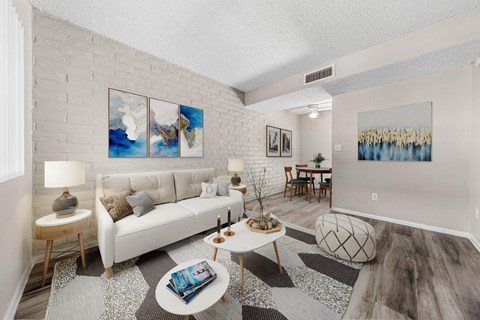 A living room with a white couch, a coffee table, and a painting on the wall.