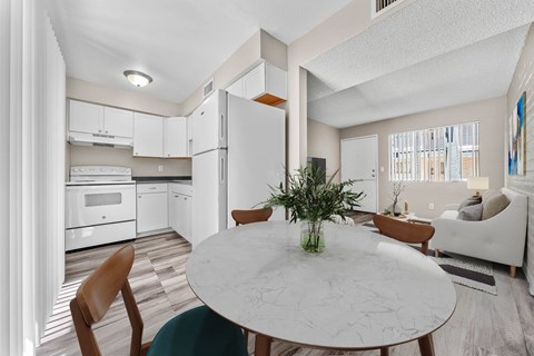 A modern kitchen with a dining table and chairs.