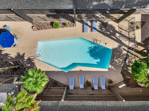 Aerial view of outdoor pool with lounge chairs and shaded seating area.