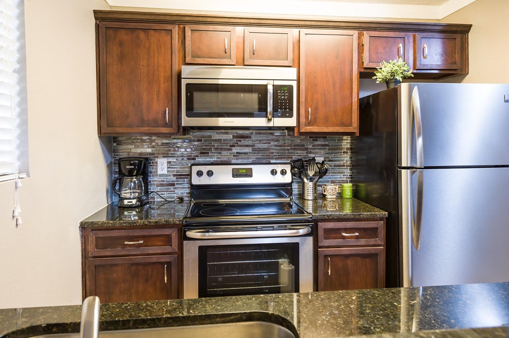 a kitchen with wooden cabinets and granite countertops