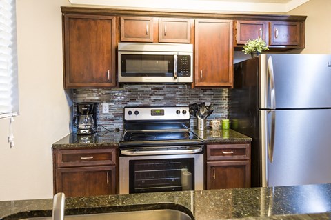 a kitchen with stainless steel appliances and granite counter tops