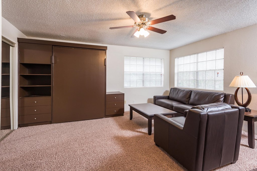 a living room with a couch coffee table and a ceiling fan