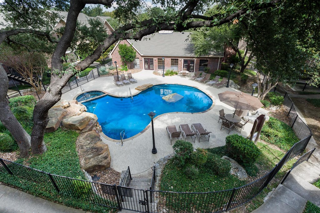 an aerial view of a backyard with a pool and patio