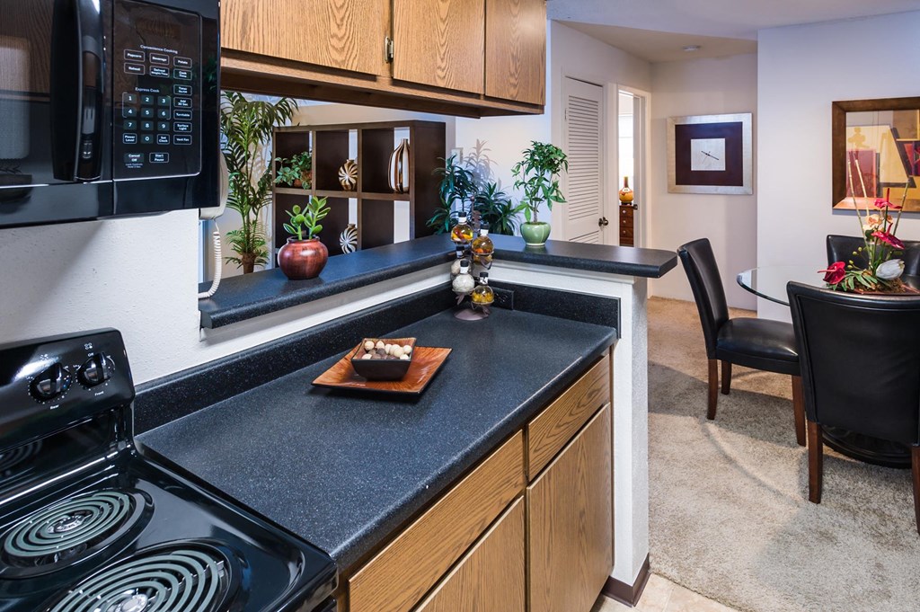 a kitchen with a stove top oven next to a table with a chair