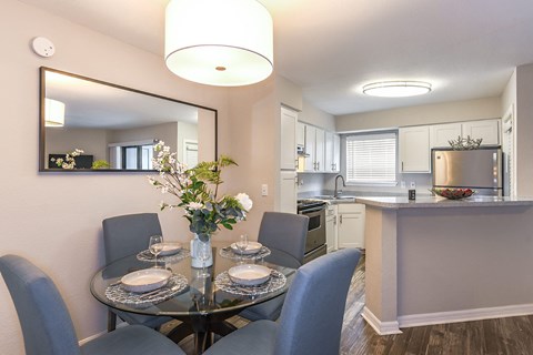 A dining room with a glass table and chairs.
