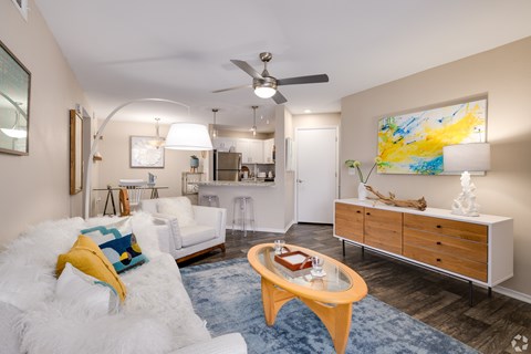 A living room with a white couch and a yellow pillow.