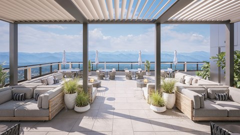 A patio with couches and plants overlooking a body of water.