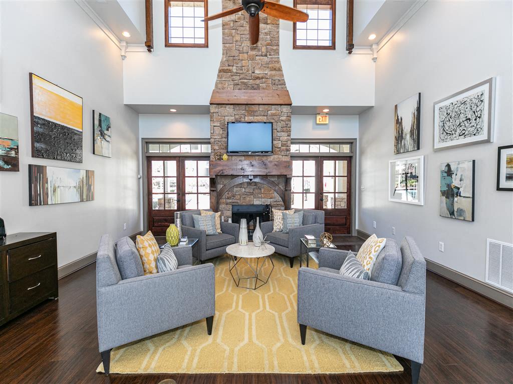 A living room with a grey couch and a fireplace.