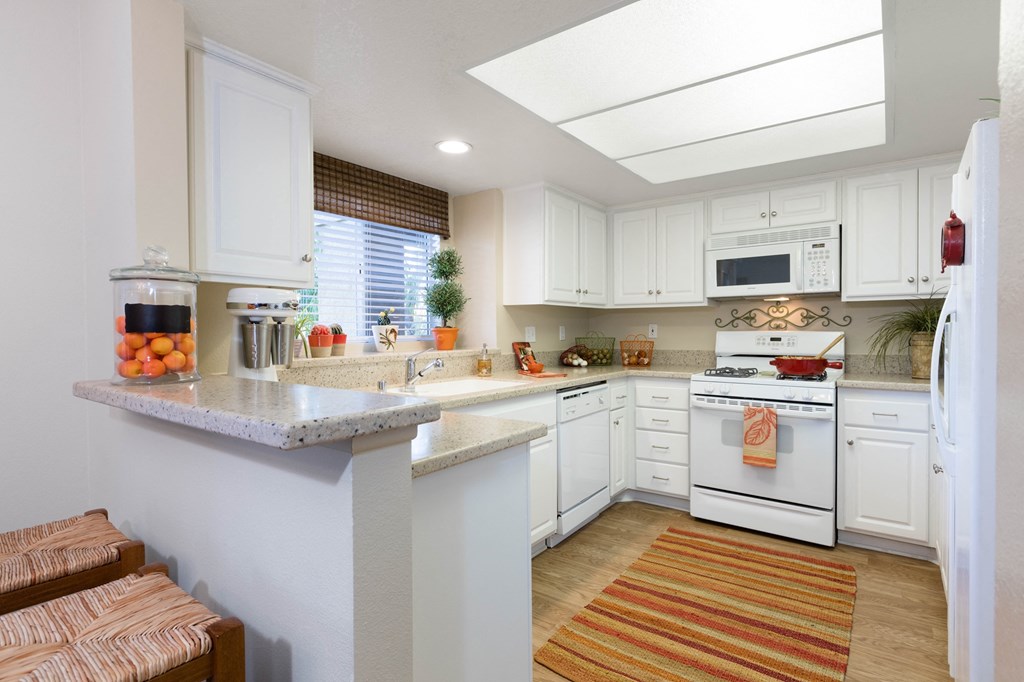 a kitchen with white cabinets and a white stove top oven