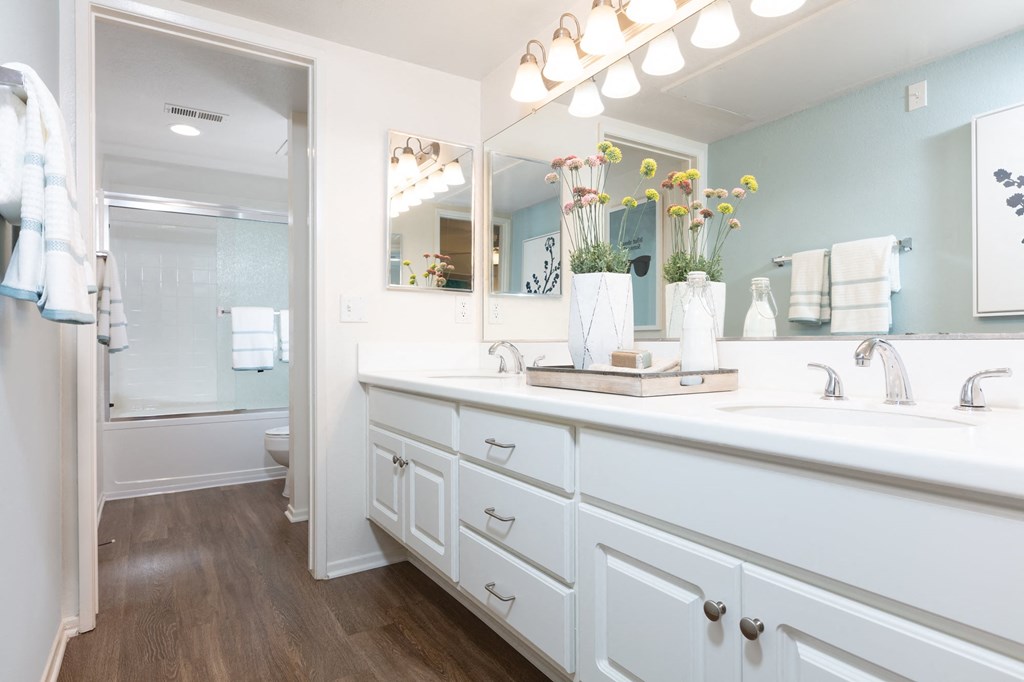 a bathroom with white cabinets and a large mirror