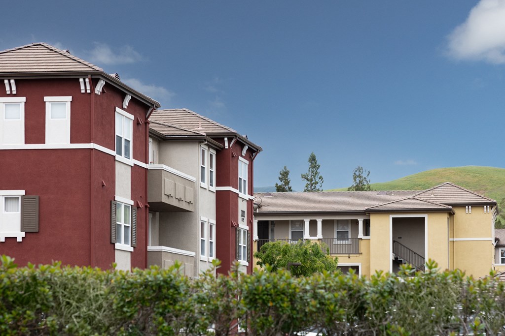 a row of apartment buildings with a mountain in the background