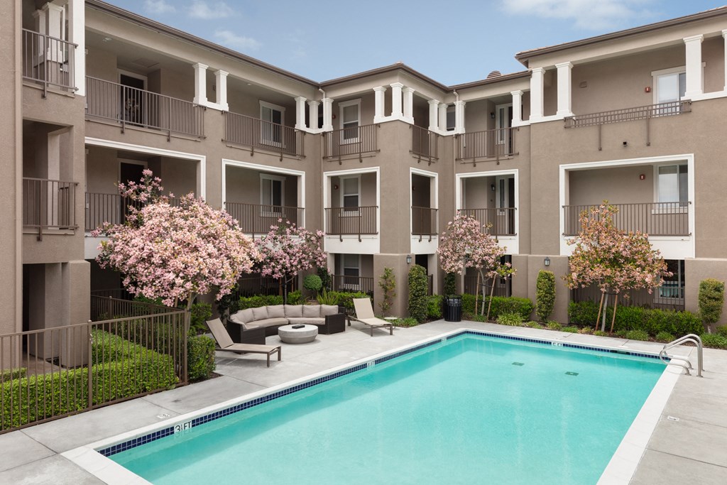 an apartment building with a swimming pool in front of it