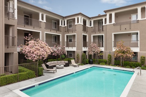 an apartment building with a swimming pool in front of it