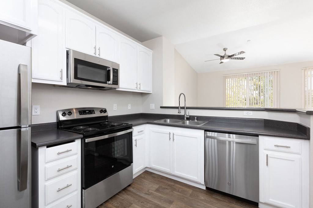 a kitchen with white cabinets and stainless steel appliances