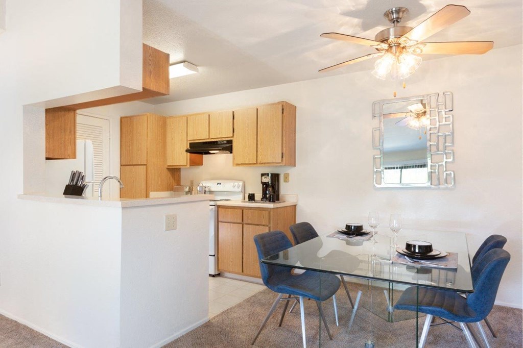 a kitchen and dining room with a glass table and chairs