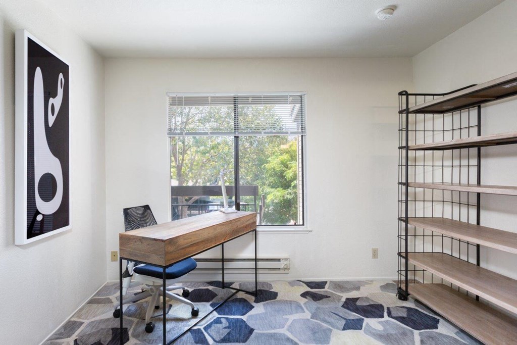 a home office with a desk and a window