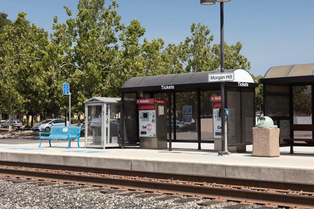 a train station with a bench next to the tracks