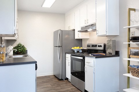a kitchen with white cabinets and a stainless steel refrigerator