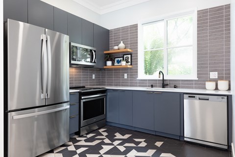 a kitchen with stainless steel appliances and gray cabinets