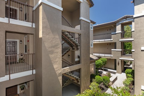 A view of a courtyard surrounded by buildings with balconies.