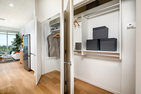 A kitchen with a refrigerator and a door open to a hallway.