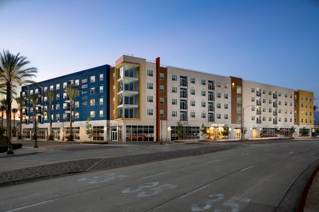 exterior view at dusk of spacious apartment complex Aston at Gateway apartments in El Monte, California