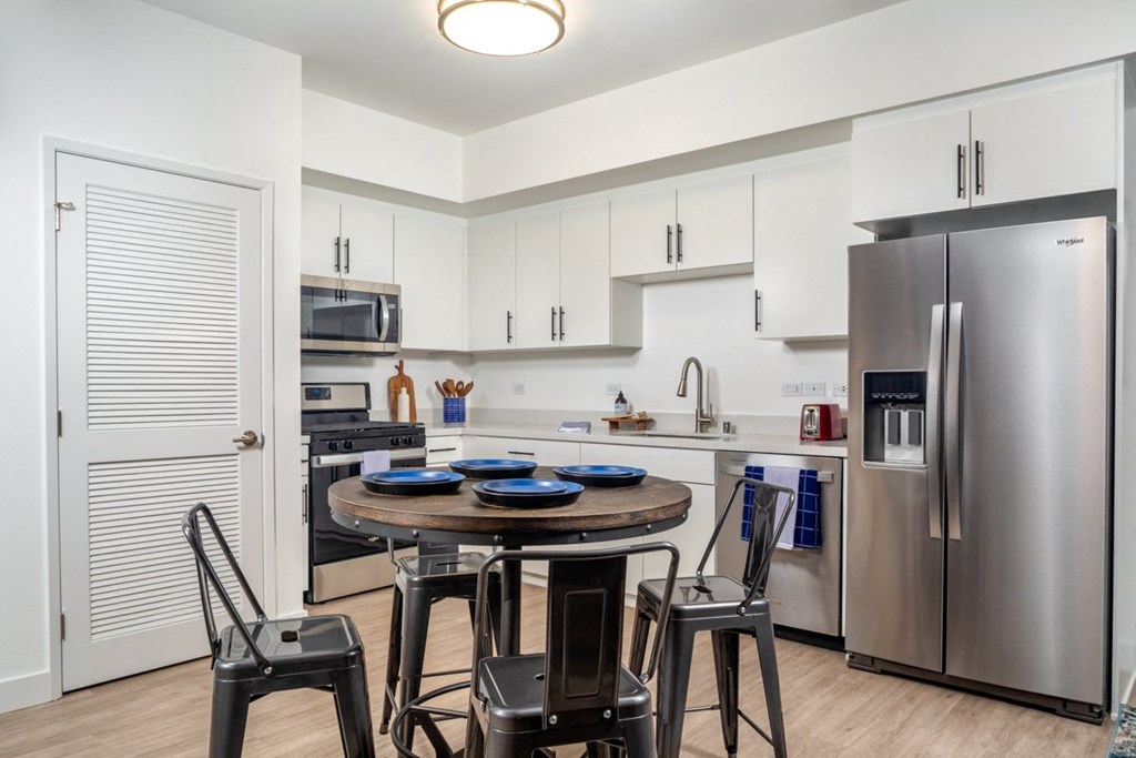 El Monte apartment kitchen with large fridge at Aston at Gateway apartments