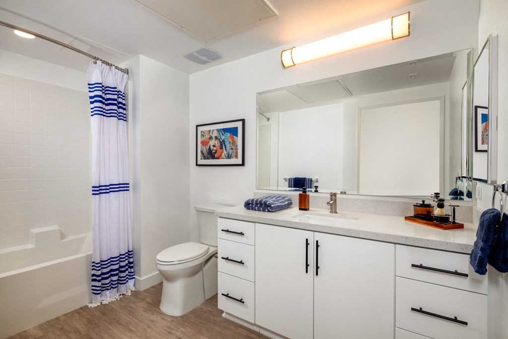 apartment bathroom with bathtub and large vanity at Aston at Gateway apartments in El Monte, California