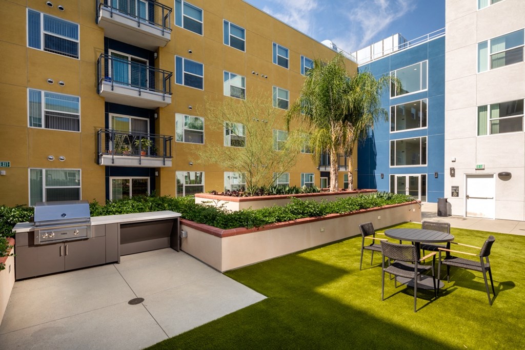 outdoor grill and greenspace  in The Yard outdoor lounge and BBQ at Aston at Gateway apartments in El Monte, California