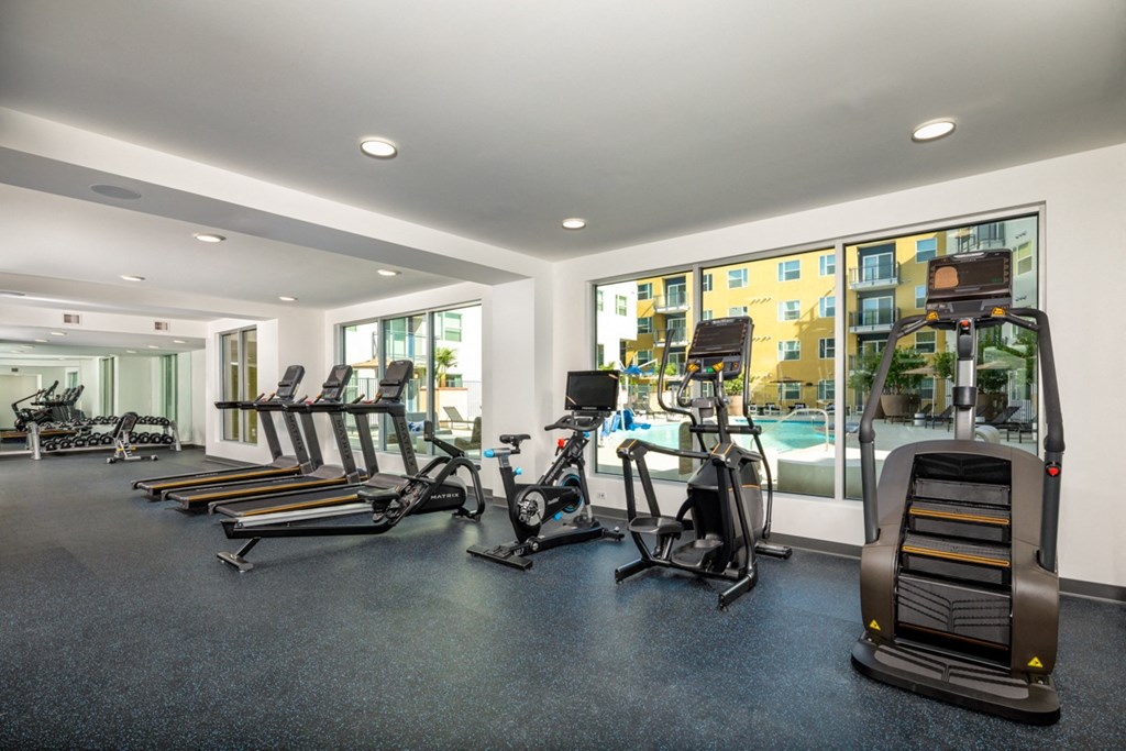 treadmills, stair stepper and rowing machine in apartment fitness center at Aston at Gateway apartments in El Monte, California