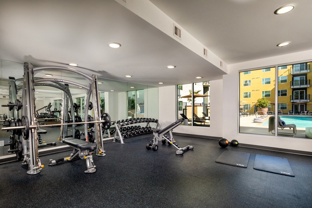 weight bench and yoga mats in apartment fitness center at Aston at Gateway apartments in El Monte, California