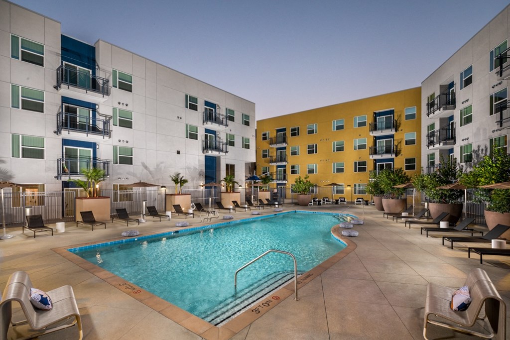 outdoor pool with sun loungers at apartment in El Monte, CA Aston at Gateway apartments